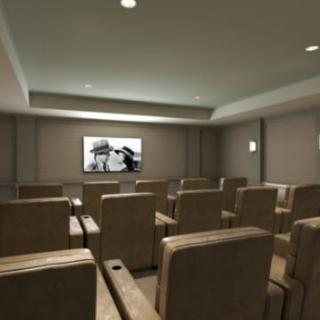 A small private movie theater with comfortable seating and a screen displaying a movie.