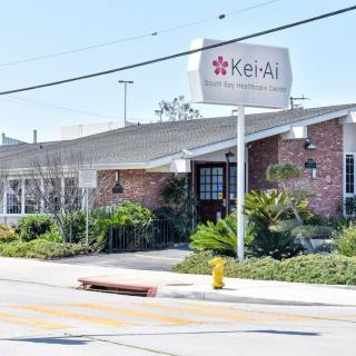 Exterior view of a brick restaurant with signage and landscaping.