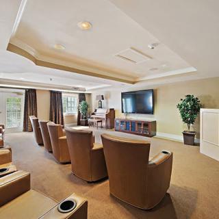 A cozy home theater room with reclining chairs and a large screen TV.