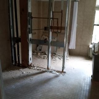 An interior space undergoing renovation, with exposed walls and construction debris.