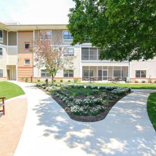 A modern apartment building with well-maintained landscaped gardens and pathways.