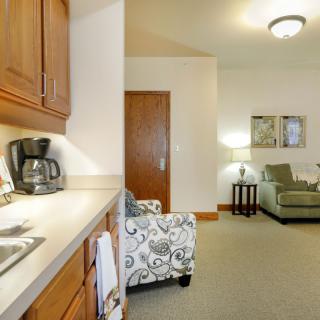 A cozy living area with a kitchenette featuring wooden cabinets and comfortable seating.