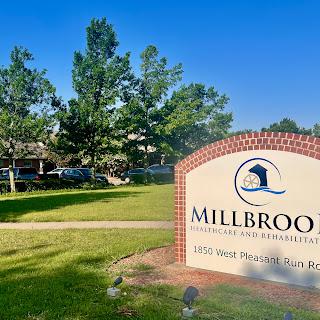 Entrance to Millbrook Community, showcasing a welcoming sign and lush surroundings.