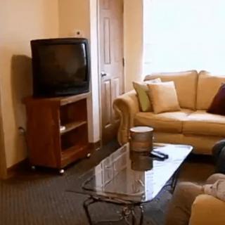 A cozy living room featuring a sofa, television, and coffee table.