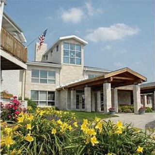 A beautiful residential building surrounded by vibrant flowers and a clear blue sky.
