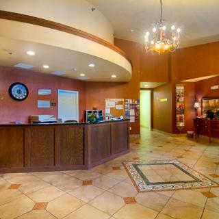 A warmly lit hotel lobby with a reception desk and seating area.
