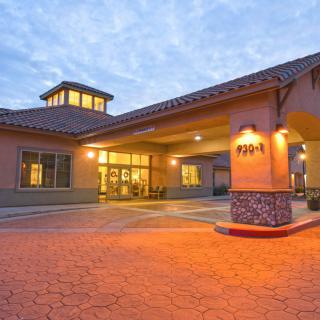 The warmly lit exterior entrance of a hotel during the evening.