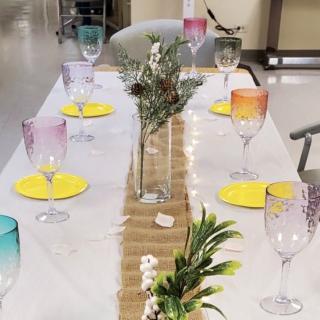 A beautifully decorated dining table with colorful glassware and floral centerpieces.
