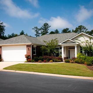 A single-story suburban house with a well-maintained lawn and driveway.