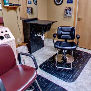 A cozy barbershop interior featuring a barber chair and surrounding furniture.
