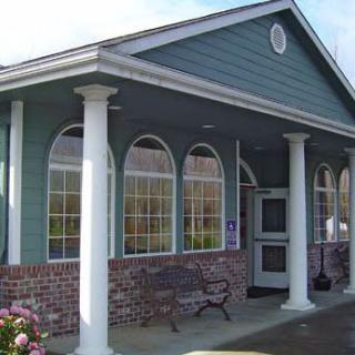A small building with columns and large arched windows at the entrance.