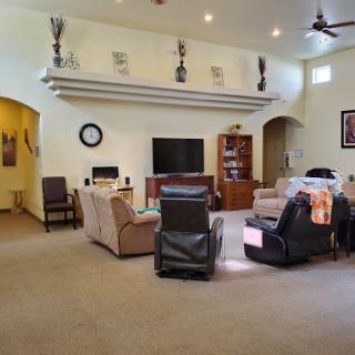 A spacious living room featuring comfortable seating, a television, and decorative elements.