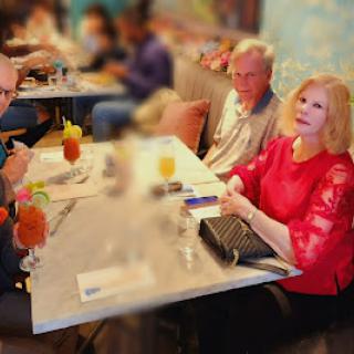 A lively gathering at a restaurant, enjoying drinks and good company.