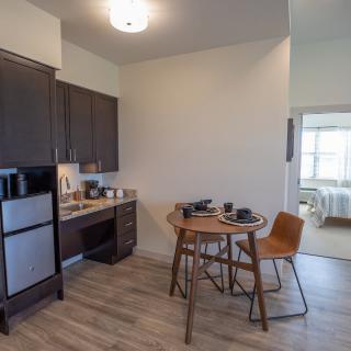 A modern apartment kitchen with a small dining area.