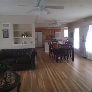 A spacious open-concept living and dining area with wooden flooring and modern furnishings.