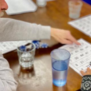 People playing bingo with cards on a table.