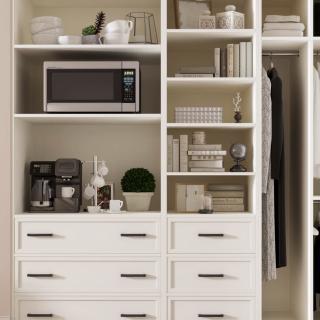 A well-organized kitchen shelving unit with a microwave, books, and various kitchen items.