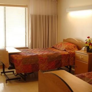 A hospital room with two beds and a window.