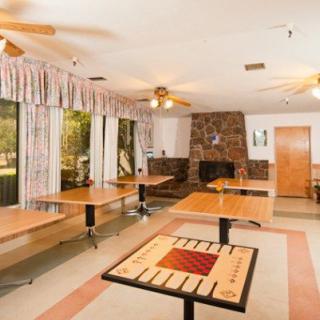 A spacious dining room with several tables and chairs, featuring a fireplace and large windows.