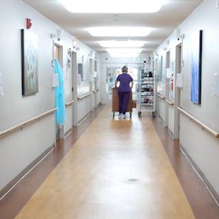 A healthcare professional walking down a hospital corridor.