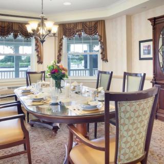 A beautifully set dining table in a well-decorated room with elegant furnishings and natural light streaming through the windows.