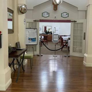 A view of a hallway leading to an office entrance with wooden flooring and decorative elements.