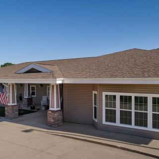 A residential-style building with a porch and an American flag.