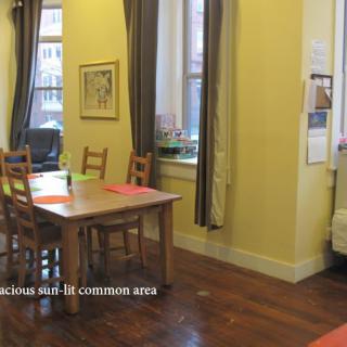 A cozy dining area with wooden chairs and tables situated in a warm, inviting common space.