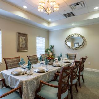 A beautifully decorated dining room with an elegant table setting and chandelier.