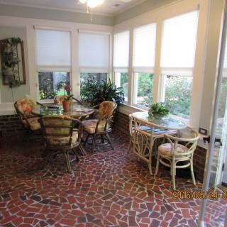 A cozy sunroom with wicker furniture and large windows letting in natural light.