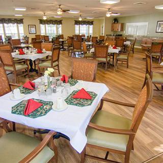 A spacious dining area with neatly arranged tables and chairs, featuring decorative table settings.