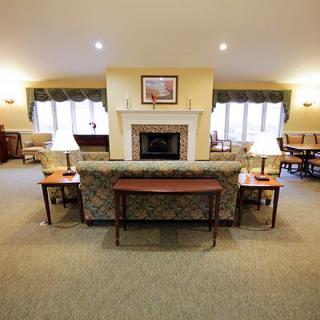 A cozy living room with a central fireplace, surrounded by comfortable seating and warm lighting.