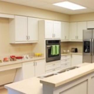 A modern kitchen with white cabinets and stainless steel appliances.