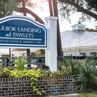 Entrance sign for Harbor Landing at Pawleys with a view of the building in the background.