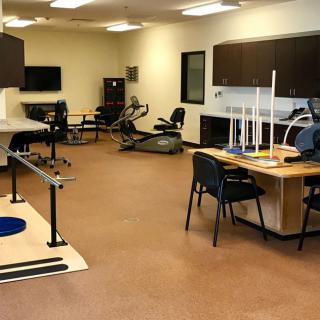 A physical therapy room equipped with various exercise and rehabilitation tools.