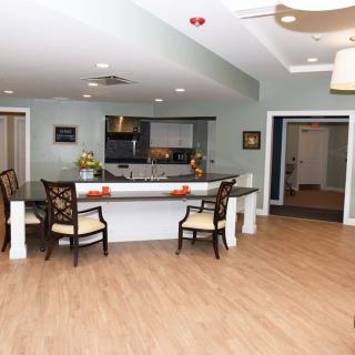 A modern kitchen and dining area with a wide counter and chairs.