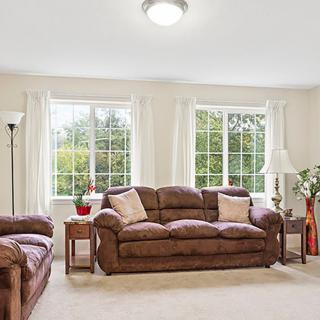 Cozy living room with sofas and large windows creating a bright and inviting space.