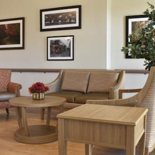 A cozy living room setup featuring comfortable seating, a wooden coffee table, and framed photographs on the wall.