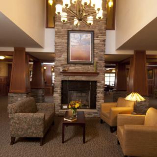 A cozy hotel lobby with a central fireplace and comfortable seating.