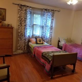 A cozy bedroom with twin beds and a wooden floor.