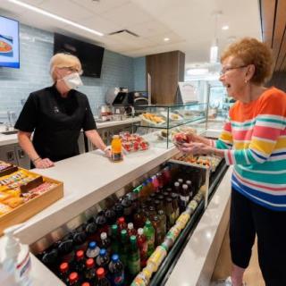A friendly interaction between a server and a customer at a cafe counter.