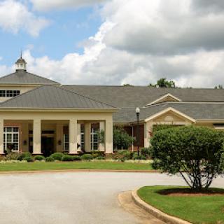 A beautifully designed residential building set against a partly cloudy sky.