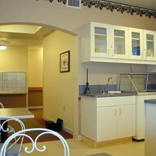 A clean and well-organized kitchen with white cabinets and a built-in sink.