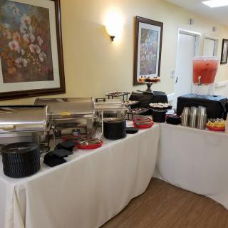 A well-arranged buffet table with various food and drink options in an indoor setting.