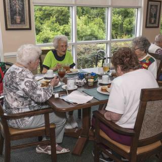 A group of seniors dining together in a community setting.