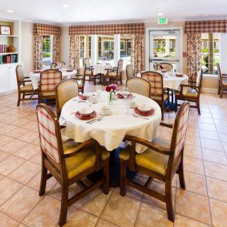 A cozy dining room with neatly arranged tables and chairs, set for a meal.
