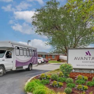 A bus parked in front of a building with a sign reading 'Avante'.