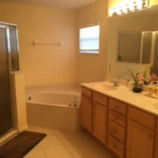 A bathroom interior with a bathtub, shower, and vanity area.