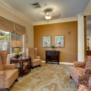 A cozy living room with comfortable armchairs, artwork on the wall, and soft lighting.