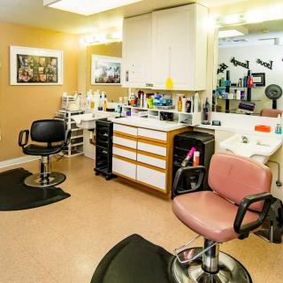 A well-organized beauty salon with styling chairs, mirrors, and various hair care products.